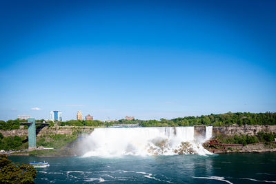 Niagara falls on a sunny day. view from canadian side with lines of tourist ready to get into a boat