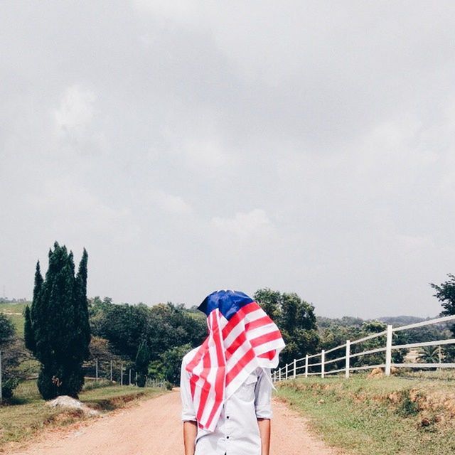 lifestyles, standing, leisure activity, sky, rear view, casual clothing, road, tree, men, red, person, day, full length, outdoors, walking, street, low section, road marking