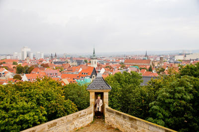 Man in city against sky
