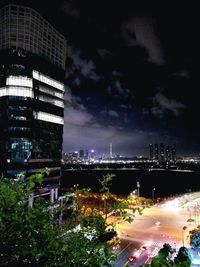 High angle view of illuminated street amidst buildings at night