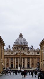 Group of people in front of historic building against sky