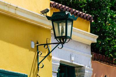 Low angle view of street light on yellow wall