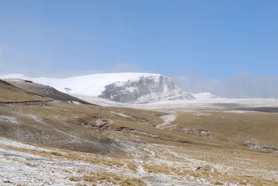 Scenic view of snowcapped mountains against clear blue sky