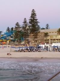 People on beach against clear sky during winter