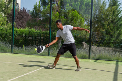 Black sportsman playing paddle tennis