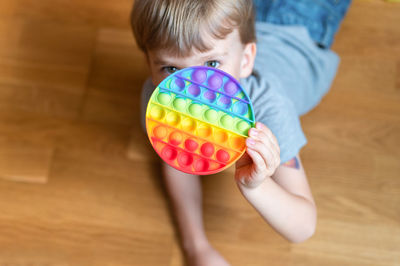 High angle view of boy playing with ball on floor