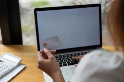 Cropped image of man using laptop on table