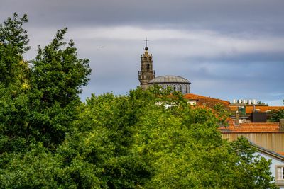 Low angle view of trees and building against sky