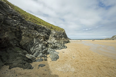 Scenic view of rocks on beach against sky