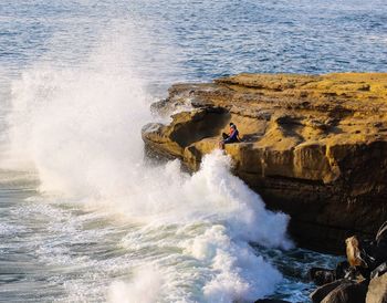 People on rocks by sea