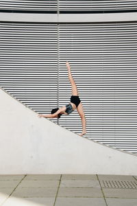 Full length of woman sitting on wall