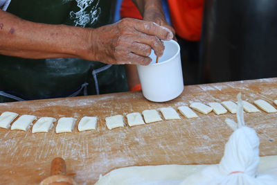 Midsection of person preparing food on table