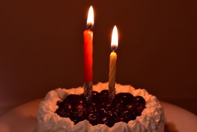 Close-up of illuminated candles on cake