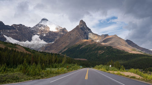 Road leading towards mountains against sky