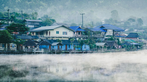 Houses by trees and buildings in city