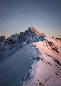 Scenic view of snowcapped mountains against sky during sunset