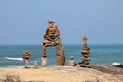 Stack of rocks on beach against clear sky