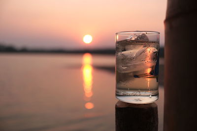 Close-up of glass of water during sunset