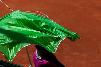 Woman standing under broken umbrella