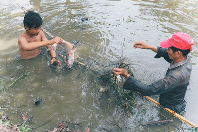 High angle view of people fishing in lake