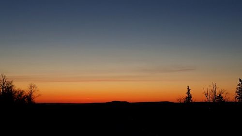 Scenic view of silhouette trees against sky at sunset