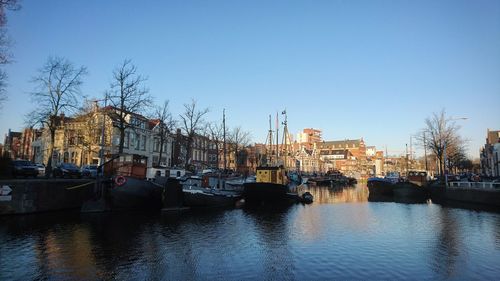 View of buildings by canal against clear sky