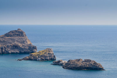 Scenic view of rocks in sea against sky