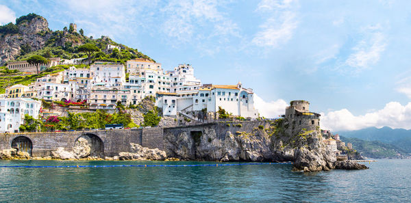 Panoramic view of small haven of amalfi village with turquoise sea and colorful houses on slopes 