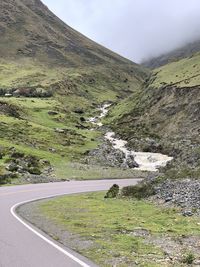Road amidst green landscape against sky