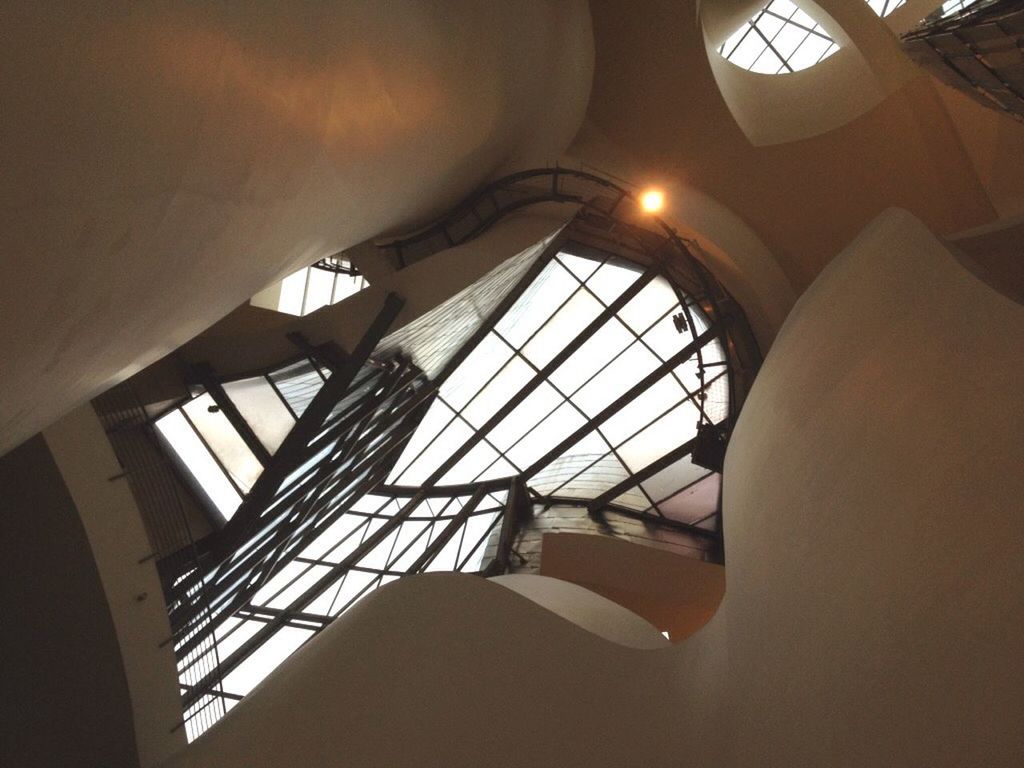 indoors, architecture, ceiling, built structure, low angle view, skylight, window, glass - material, architectural feature, interior, modern, pattern, building, arch, directly below, no people, design, illuminated, transparent, day