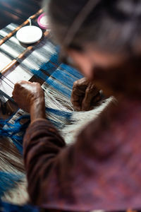 High angle view of weaving threads on loom in workshop