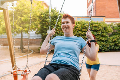 Woman pushing friend on swing