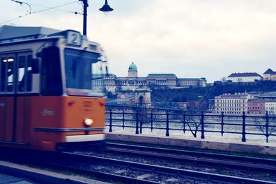 Railroad tracks in city against sky