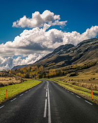 Surface level of road along landscape against sky