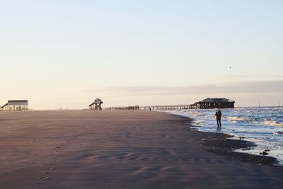 Full length of woman standing on beach against sky