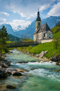 Water flowing by building against sky