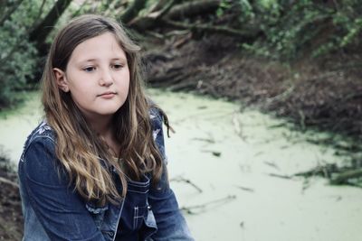 Portrait of teenage girl standing against tree