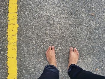 Low section of man standing on road