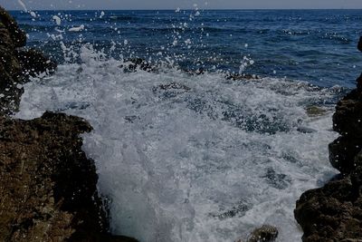 Scenic view of sea waves splashing on rocks