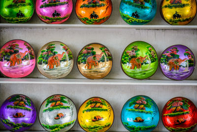 Close-up of multi colored crockery in shelf for sale