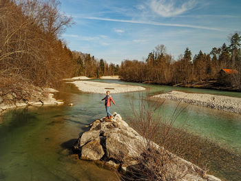 Person by river against blue sky