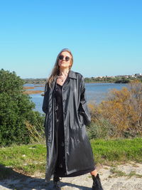 Portrait of woman wearing sunglasses standing against clear sky