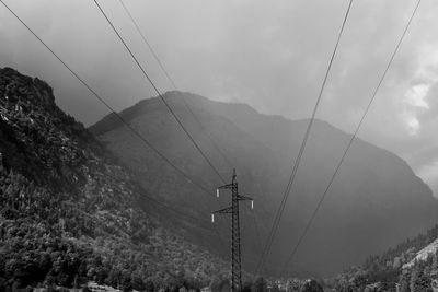 Overhead cable car over mountains against sky