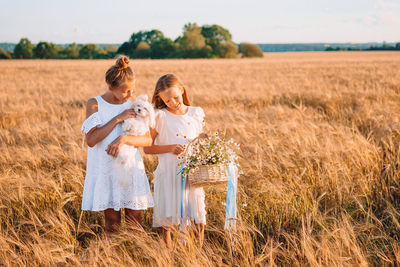 Mother and daughter standing on field