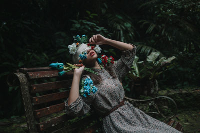 Full length of woman sitting against plants