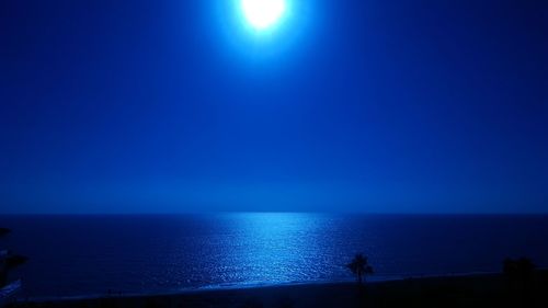 Scenic view of sea against clear blue sky at night