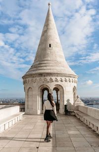 Girl standing on walls in front of spire at fisherman's bastion in budapest, hungary