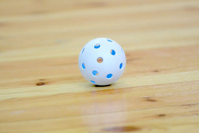 Close-up of white ball on wooden table