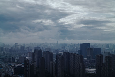 View of urban skyline against cloudy sky