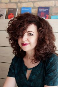 Portrait of smiling woman against books